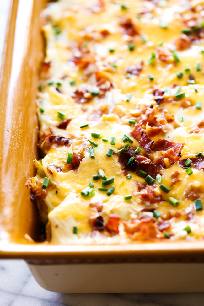 Loaded Scalloped Potatoes... Bacon, sour cream, cheese, chives and all your favorite baked potato toppings come together for one unforgettable side dish! This will become a family favorite!