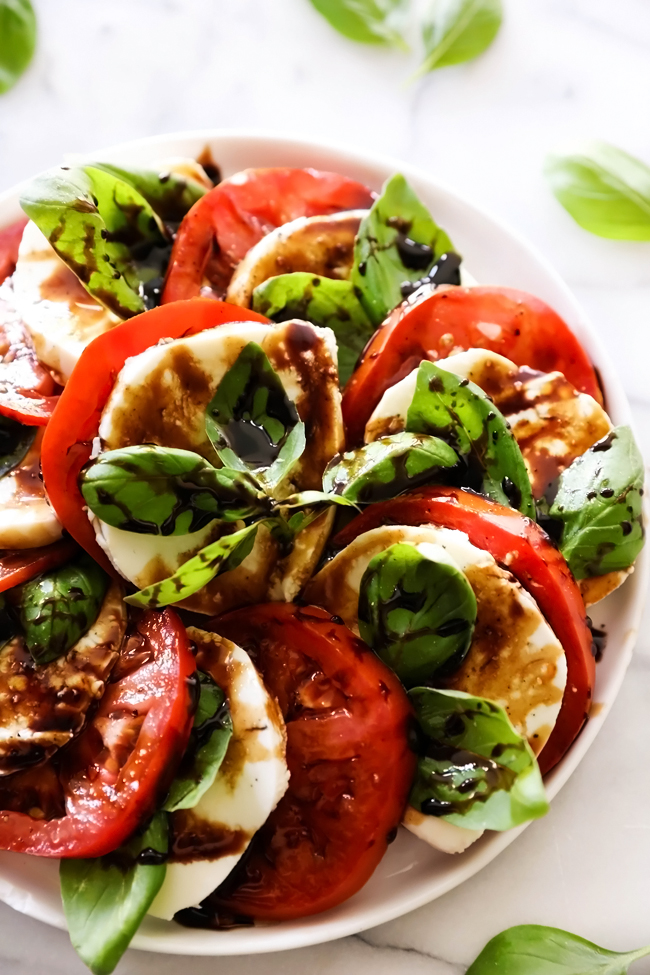 Caprese Salad with Balsamic Glaze... A refreshing and light salad comprised of tomatoes, mozzarella and basil. It is topped with an incredible Honey Balsamic Glaze that ties all the flavors together for an incredible meal, side dish or snack.
