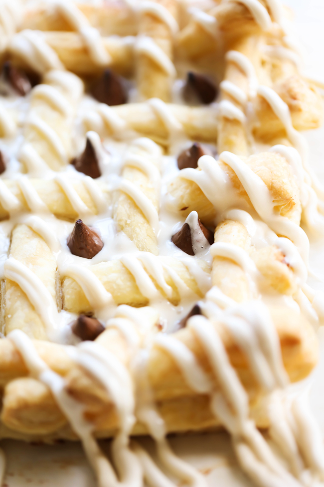 This HERSHEY'S KISSES Cream Cheese Pastry consists of buttery flaky puff pastry, a delicious cream cheese filling, is topped with HERSHEY'S KISSES Chocolates and drizzled with a creamy glaze. This dessert whips up in no time at all and tastes incredible! #sponsored HERSHEY'S Chocolate