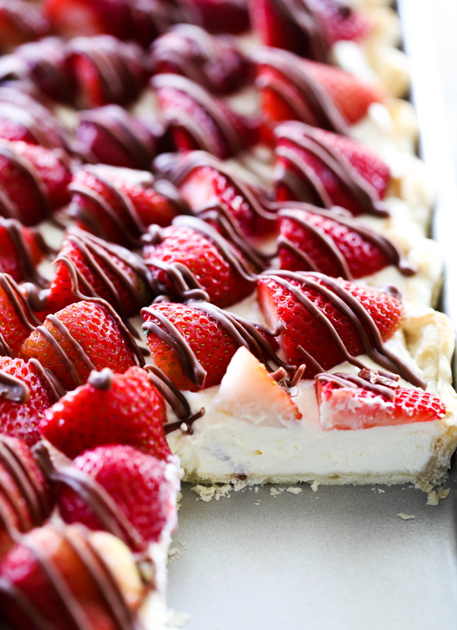 This Strawberry Cream Slab Pie is the PERFECT summertime dessert! The strawberries are beautifully topped on a cream pie and drizzled with chocolate. This is a great dessert for feeding a crowd and is ALWAYS a hit!