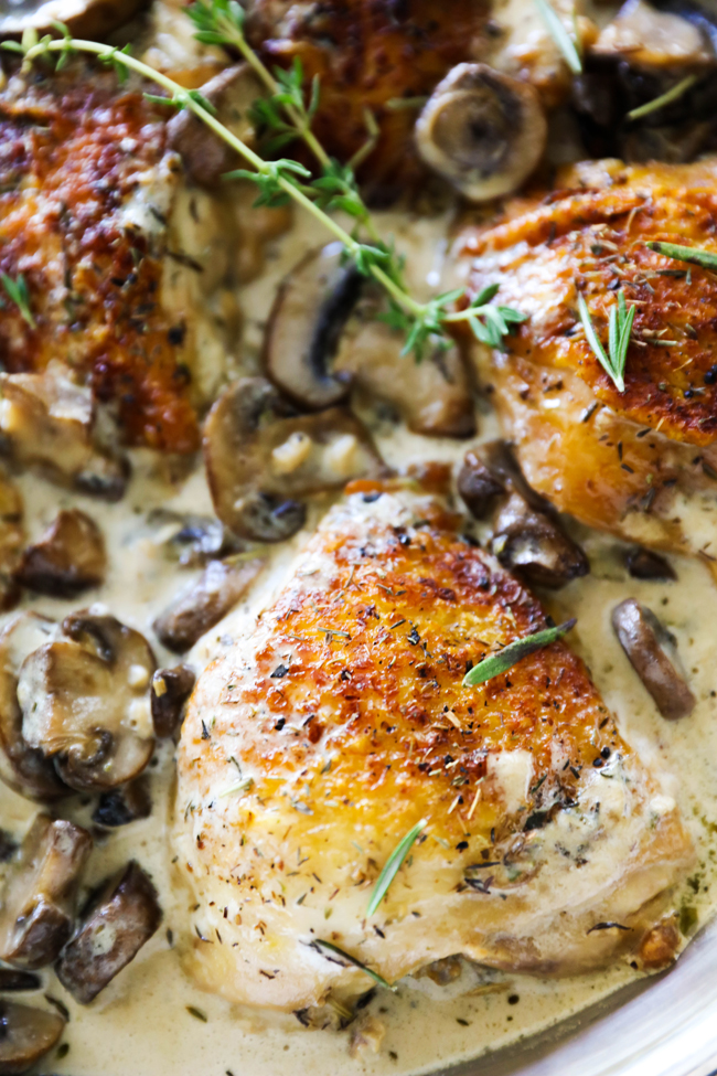 Close up of Creamy Garlic Herb Chicken garnished with rosemary in a skillet.