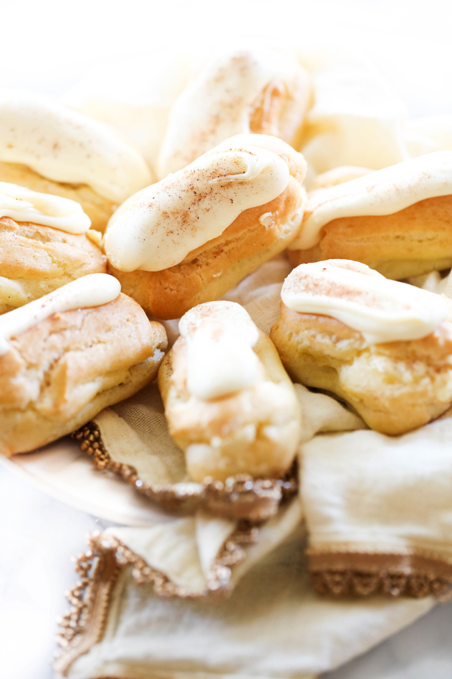 Eggnog Eclairs displayed on a white plate with a beige napkin.