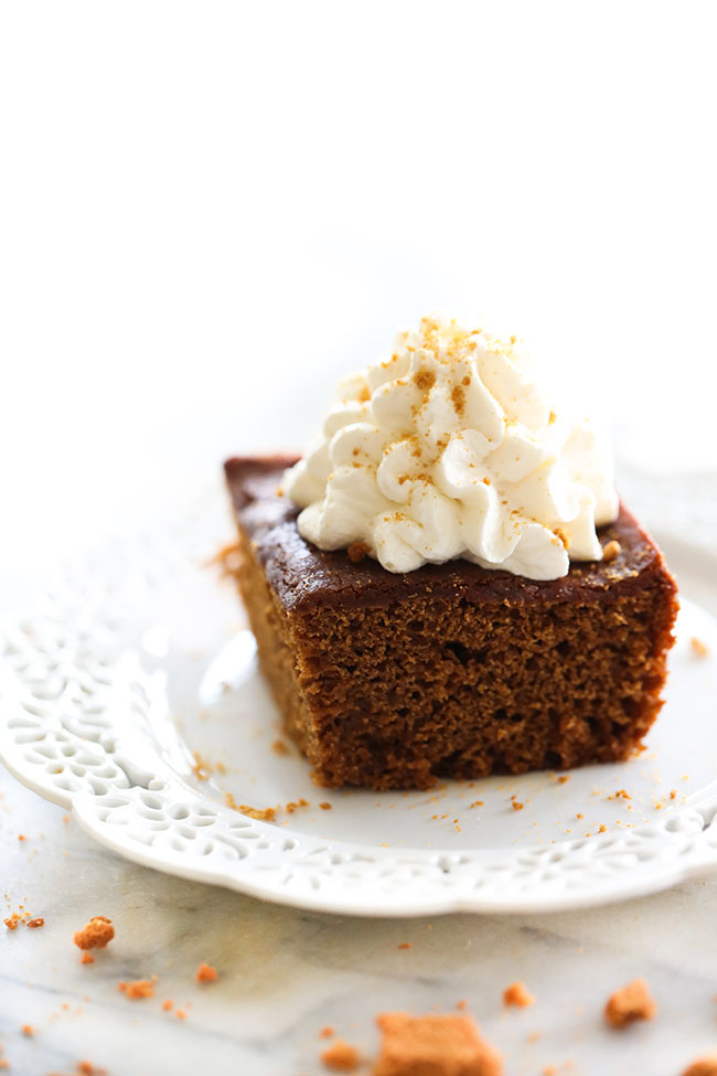 Slice of Gingerbread Cake topped with whipped cream.