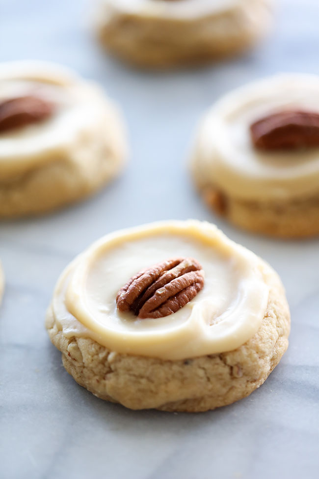 Four Pecan Cookies topped with Caramel Icing and a pecan.